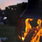 a fire pit sitting on top of a lush green field