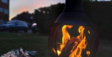 a fire pit sitting on top of a lush green field