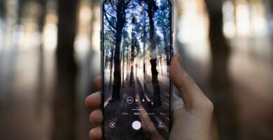 person holding black smartphone taking photo of city lights during night time